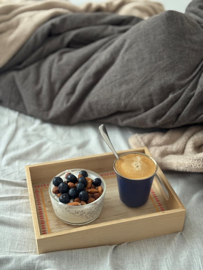 The Art of Drawing Readers In: Your attractive post title goes here Warm and inviting breakfast set in bed featuring granola with blueberries and a cup of coffee.